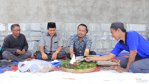 Kepala BKLH, K. Fahri Nur Chotim (songkok nasional) bersama Kepala Biro Umum PP. Nurul Jadid, KH. Faiz AHZ (baju batik) saat pemotongan tumpeng