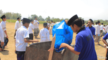 salah satu anggota BKLH Nurul Jadid (kaos biru) sedang membuang sampah di gerobak sampah