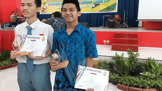 Muhammad Fadil Hasan (baju biru) saat memegang trofi dan sertifikat didepan podium